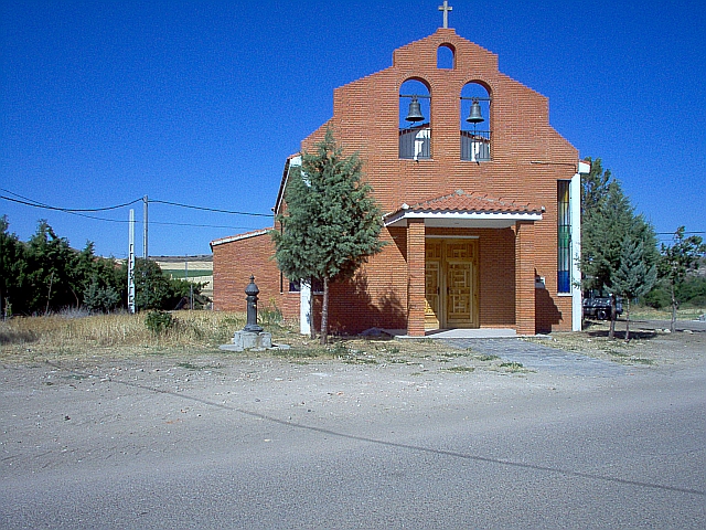 A new church in brick, surrounded by dry arid scrub and bush